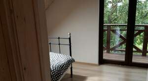 Sypialnia z wyjściem na balkon w domu całorocznym